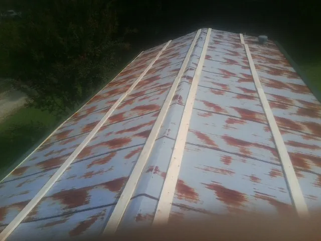 Rusted metal roof panels with new wood purlins before replacement — Storm Damage Roof Repair in Montgomery by Roofing Brothers