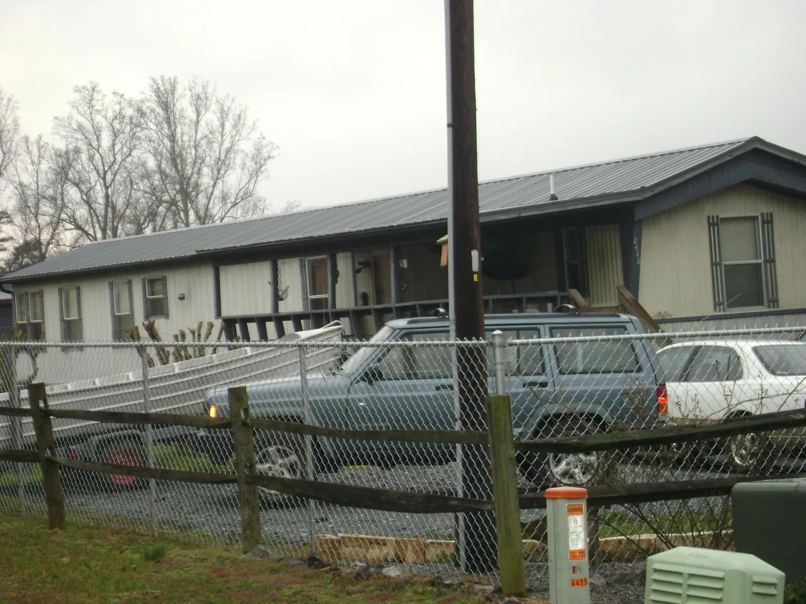 Dark metal roof on a long single story building behind a chain link fence in Montgomery